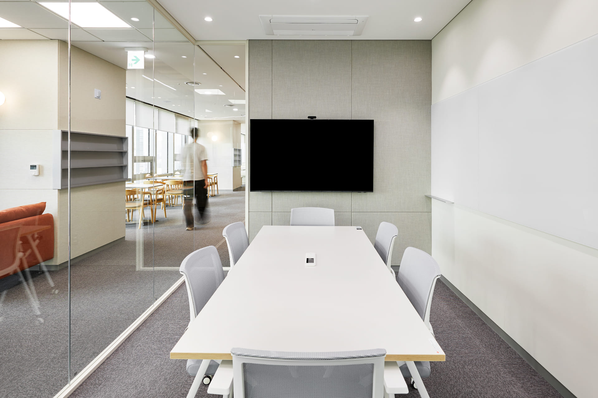 대형 모니터와 화이트보드가 설치된 화이트 톤의 깔끔한 6인용 소형 회의실 인테리어.jpg