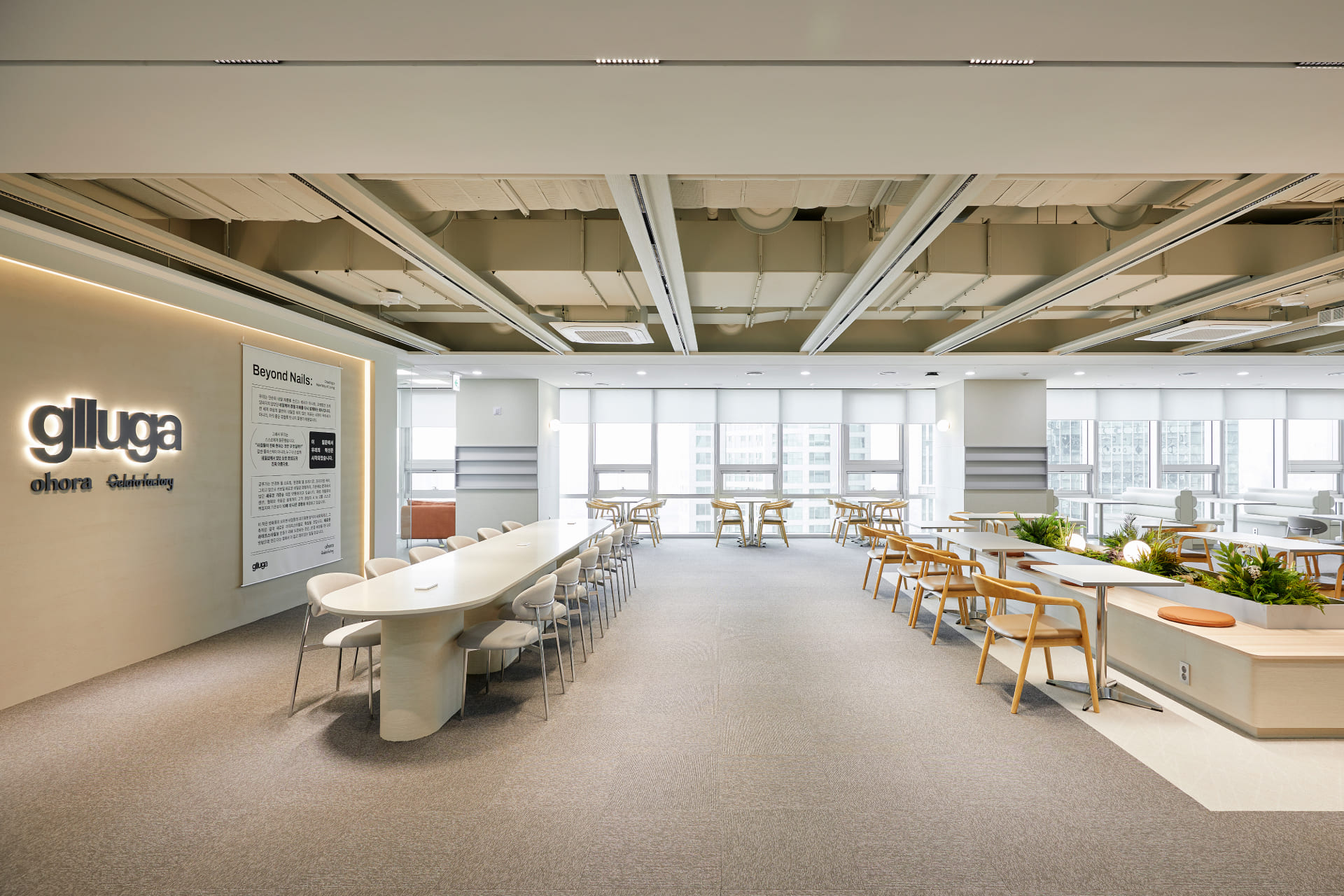 글루가 브랜드 슬로건이 게시된 아트월과 고급스러운 대형 회의 테이블이 있는 라운지 전경.jpg