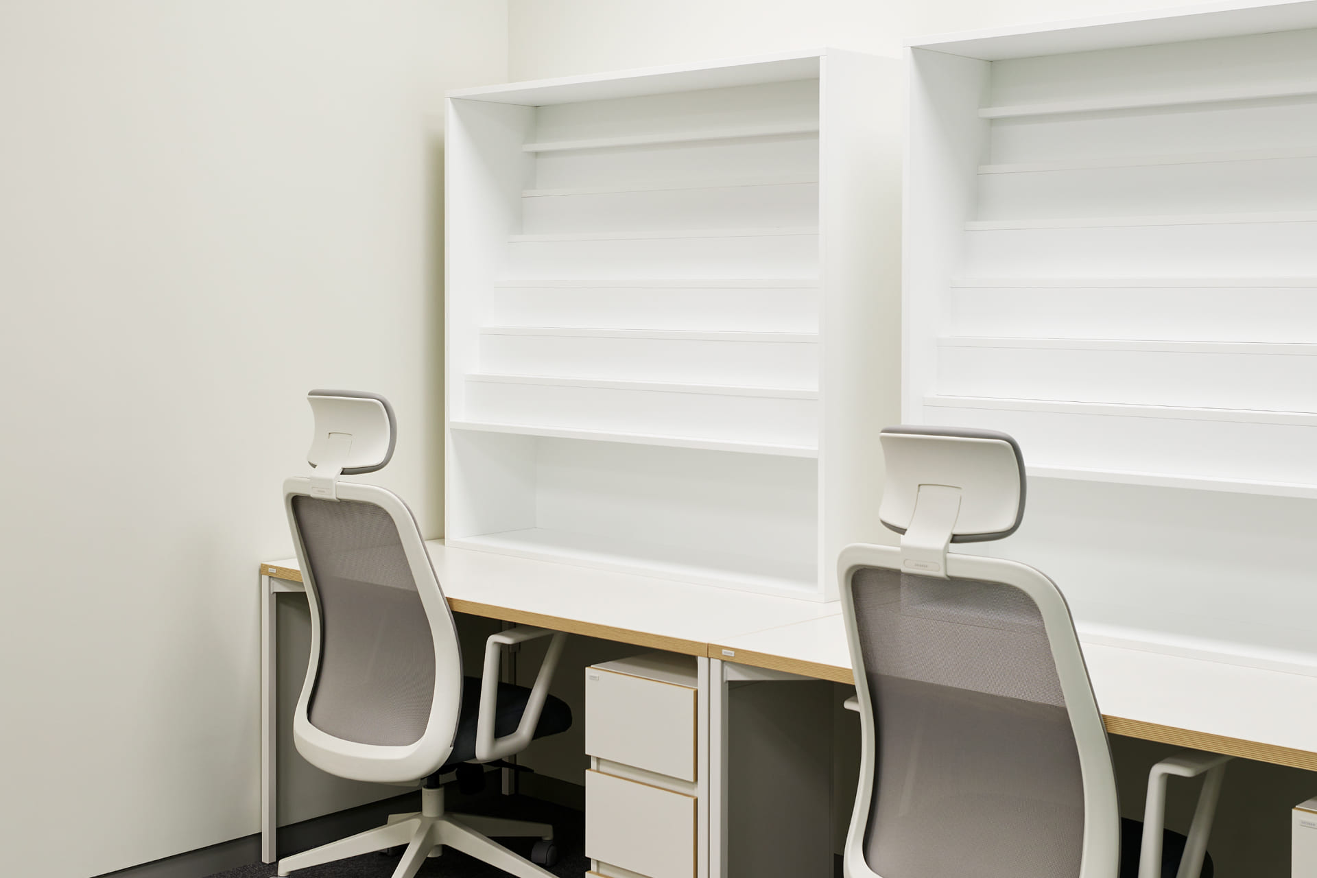 화이트 파티션 책상과 인체공학적 사무용 의자가 배치된 집중 업무용 개인 데스크 공간.jpg
