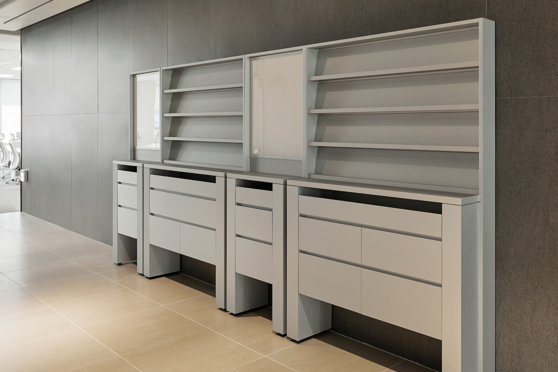 그레이 톤의 벽면과 조화를 이루는 모던한 디자인의 그레이 컬러 사무용 수납장과 진열대.jpg