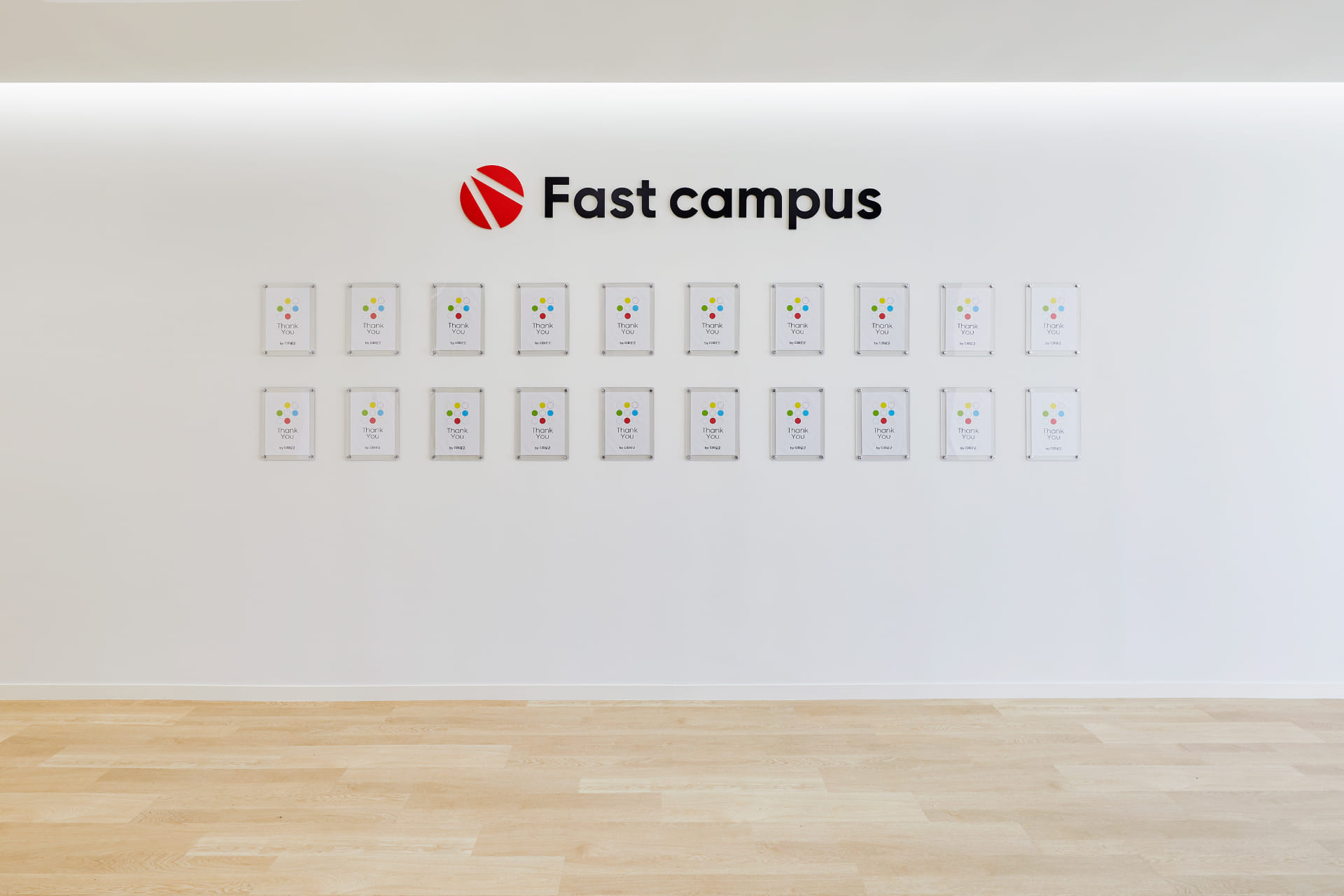 패스트캠퍼스 브랜드 학원 안내문이 전시된 미니멀한 화이트 로비 월.jpg