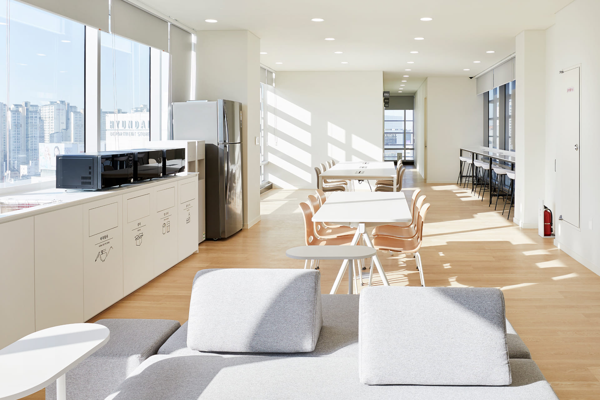 전자레인지와 냉장고가 구비된 패스트캠퍼스 캔틴 공간 및 우드 톤의 오픈 라운지 휴게 시설.jpg