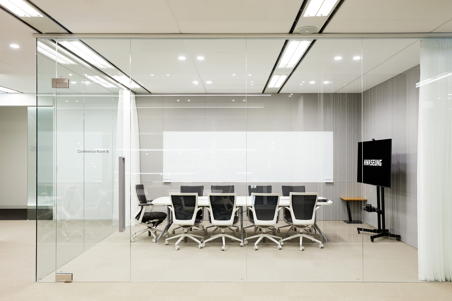 대형 화이트보드와 모니터가 구비된 통유리 파티션 구조의 8인용 스마트 회의실 내부 전경.jpg