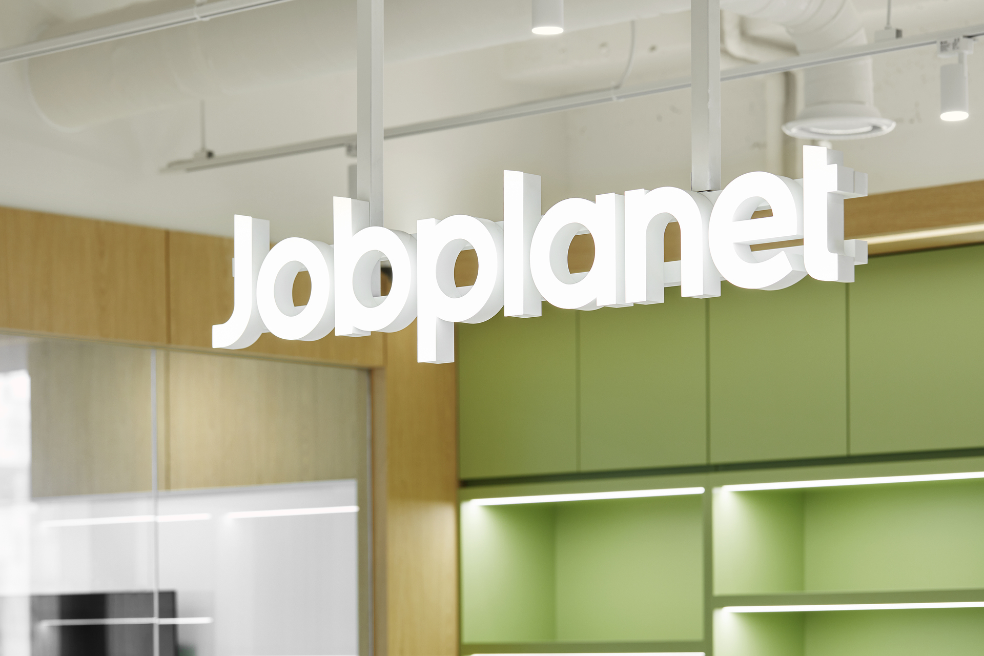 노출 천장 아래 화이트 아크릴로 제작된 Jobplanet 브랜드 로고 사인 조명의 근접 상세 컷.jpg